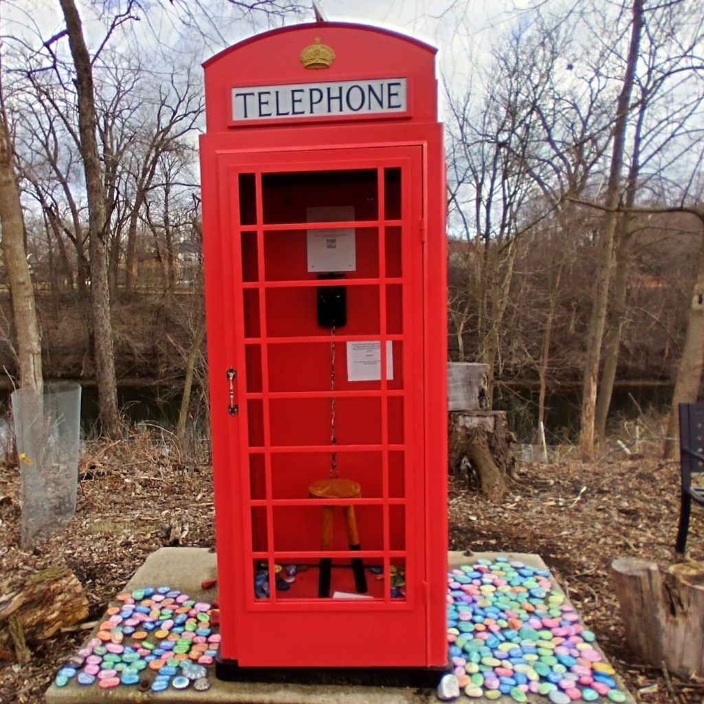 A wind phone made from an UK telephone box on a golf course in February. Surrounded by hand painted stones memorializing loved ones